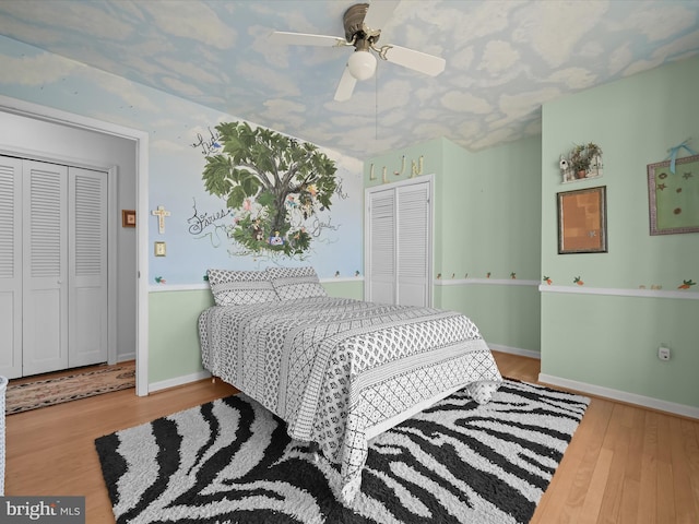 bedroom featuring a ceiling fan, a closet, baseboards, and wood finished floors