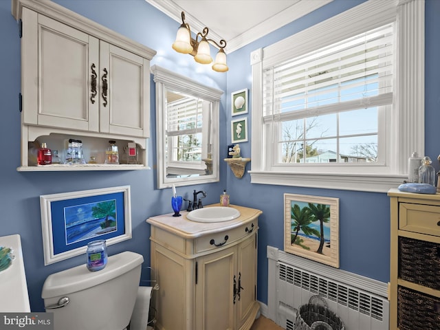 half bath featuring toilet, radiator heating unit, crown molding, and vanity