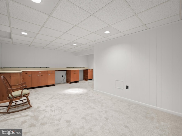 interior space with light carpet, built in desk, and baseboards