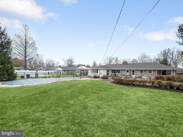 exterior space featuring a chimney, fence, a front lawn, and a fenced in pool