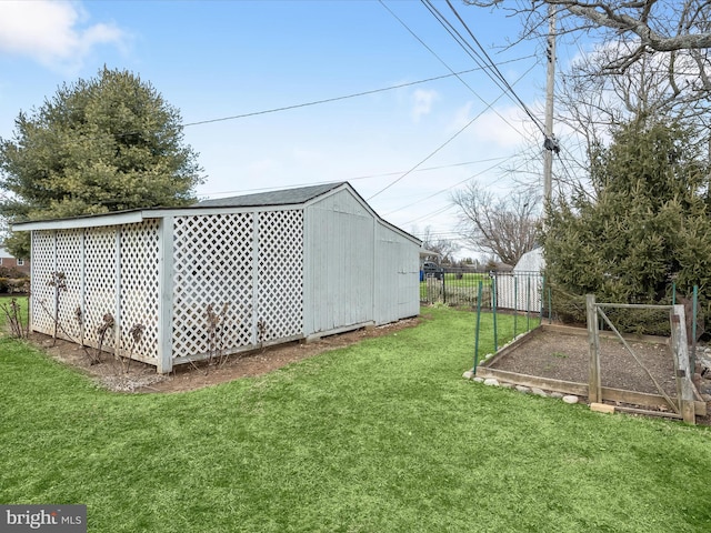 view of yard with a garden, fence, and an outdoor structure