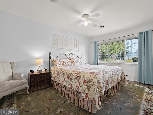 bedroom with a baseboard radiator, visible vents, and a ceiling fan