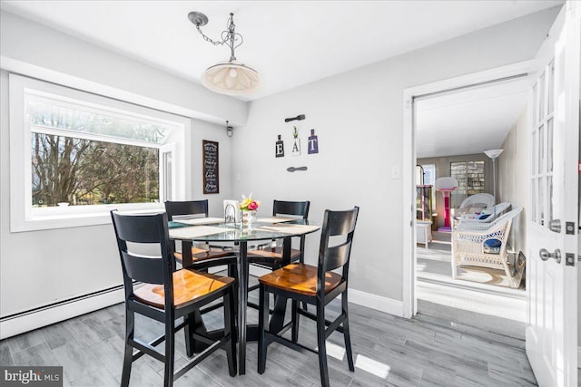 dining space featuring hardwood / wood-style floors and baseboard heating