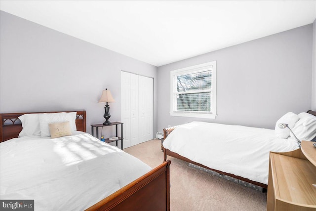 carpeted bedroom with a closet and a baseboard heating unit