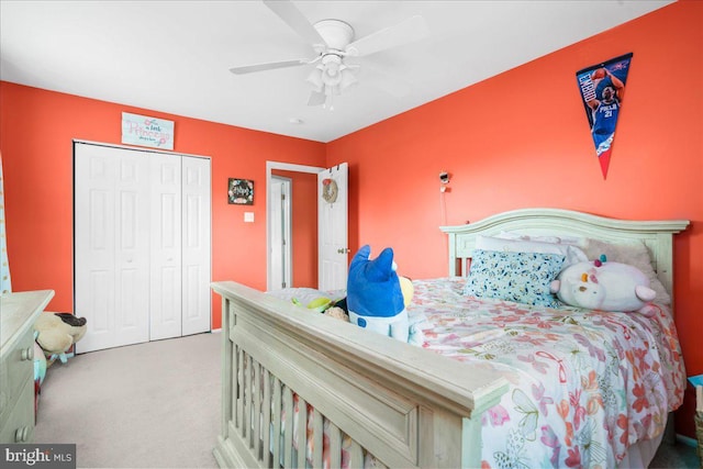 bedroom with ceiling fan, light colored carpet, and a closet