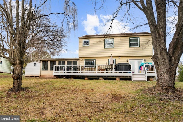 rear view of house with a yard, a deck, and a sunroom