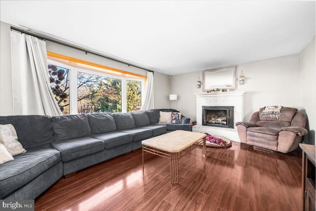 living room featuring hardwood / wood-style flooring and a brick fireplace