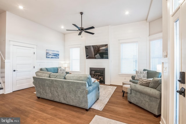 living room featuring ceiling fan, wood-type flooring, and a fireplace