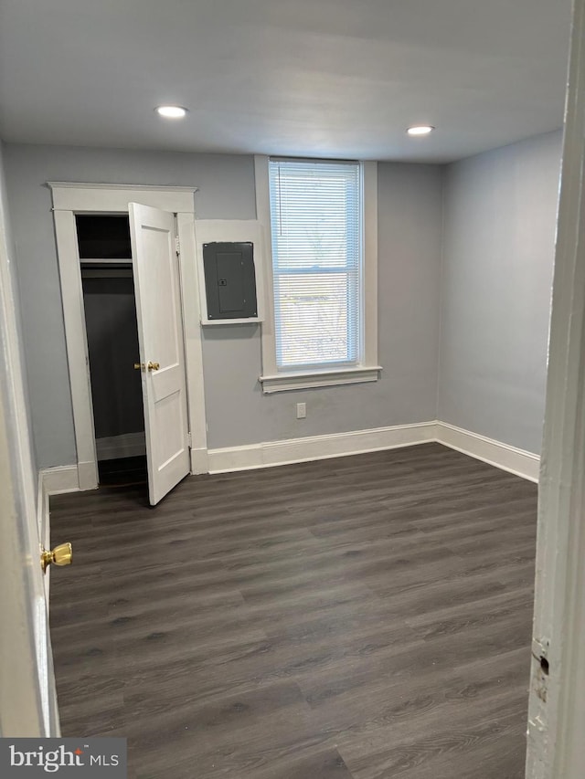 unfurnished bedroom featuring dark hardwood / wood-style flooring and electric panel