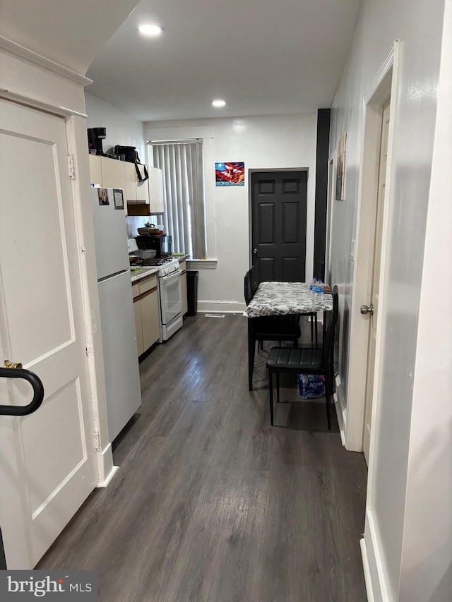 kitchen with white cabinets, white appliances, and dark wood-type flooring