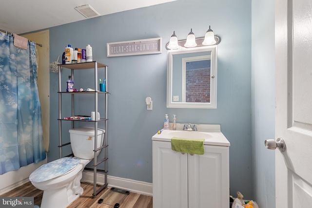 full bathroom featuring hardwood / wood-style floors, vanity, toilet, and shower / bathtub combination with curtain