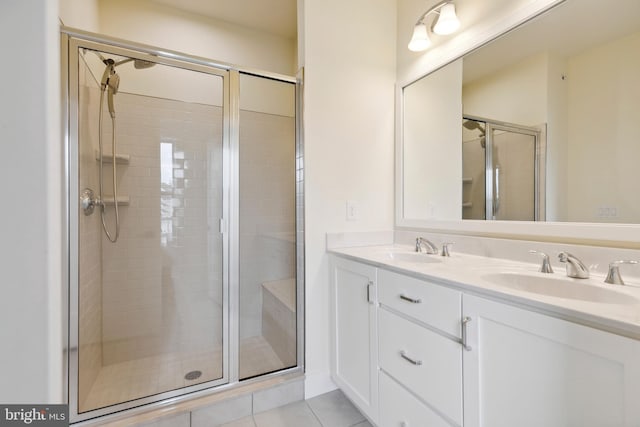 bathroom featuring tile patterned floors, a shower with door, and vanity