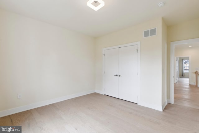 unfurnished bedroom with a closet and light hardwood / wood-style flooring