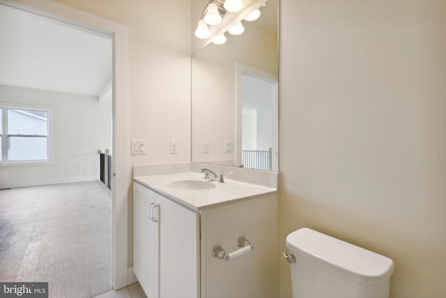 bathroom featuring wood-type flooring, vanity, and toilet