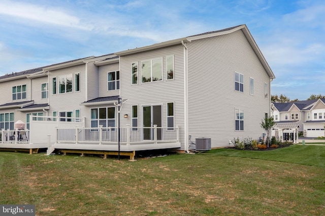 rear view of property featuring central air condition unit, a lawn, and a deck