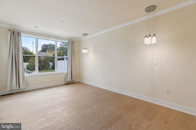 unfurnished room with a notable chandelier, light wood-type flooring, and ornamental molding