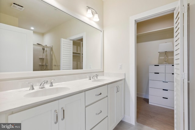 bathroom featuring hardwood / wood-style flooring, vanity, and a shower with shower door