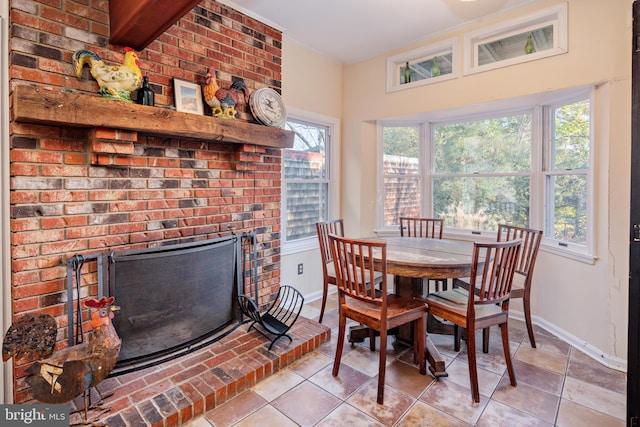 dining space featuring a fireplace and light tile patterned flooring