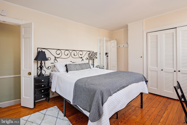 bedroom with wood-type flooring, a closet, and crown molding