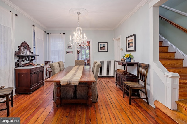 dining room with a chandelier, radiator heating unit, ornamental molding, and hardwood / wood-style floors