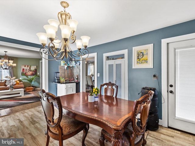 dining space with plenty of natural light, a chandelier, and light hardwood / wood-style floors