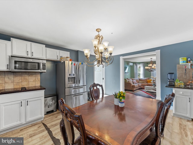 dining area featuring a notable chandelier and light hardwood / wood-style floors