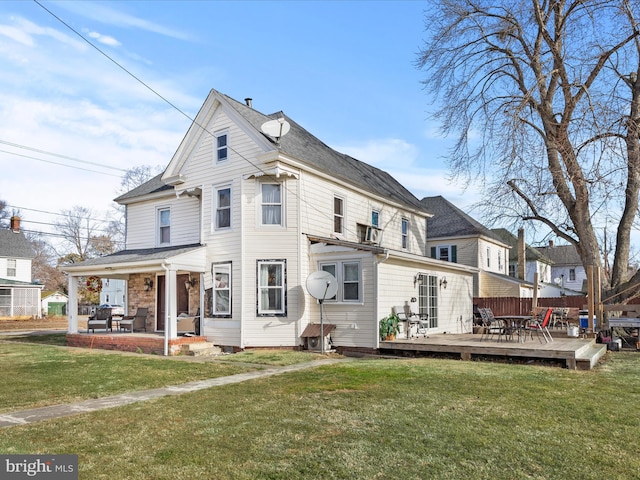 rear view of property featuring a deck and a lawn