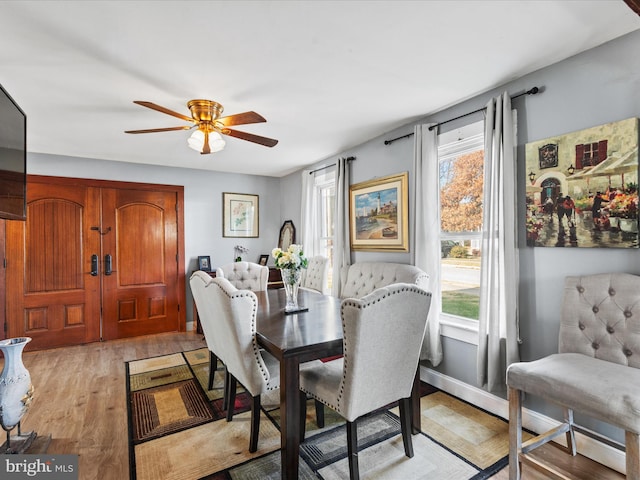 dining space with light hardwood / wood-style flooring and ceiling fan