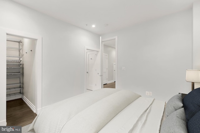 bedroom featuring hardwood / wood-style flooring, a spacious closet, and a closet