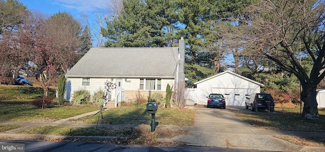 bungalow featuring a garage, an outbuilding, and a front yard