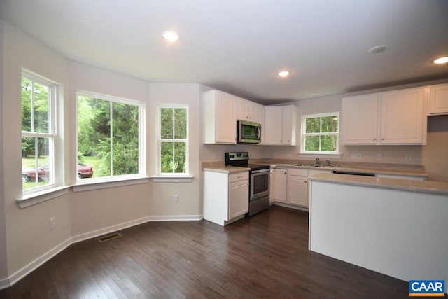 kitchen featuring white cabinets, appliances with stainless steel finishes, dark wood-type flooring, and sink