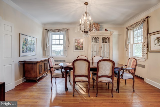 dining room with ornamental molding, radiator, a notable chandelier, and light hardwood / wood-style flooring