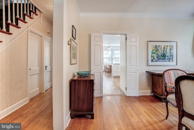 interior space featuring crown molding and light hardwood / wood-style flooring