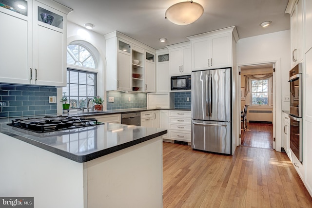 kitchen featuring white cabinetry, sink, black appliances, and kitchen peninsula