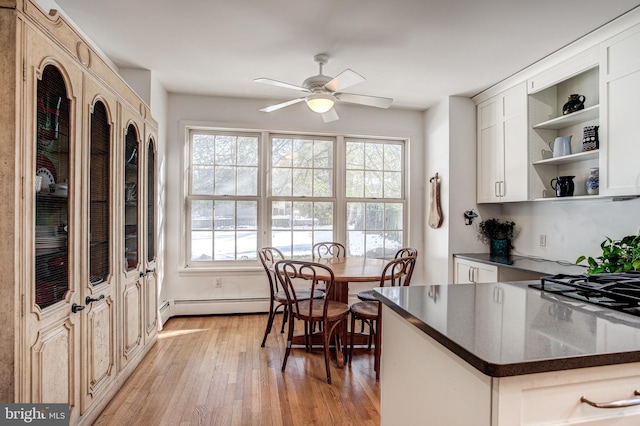 kitchen featuring white cabinets, gas cooktop, ceiling fan, light hardwood / wood-style floors, and baseboard heating