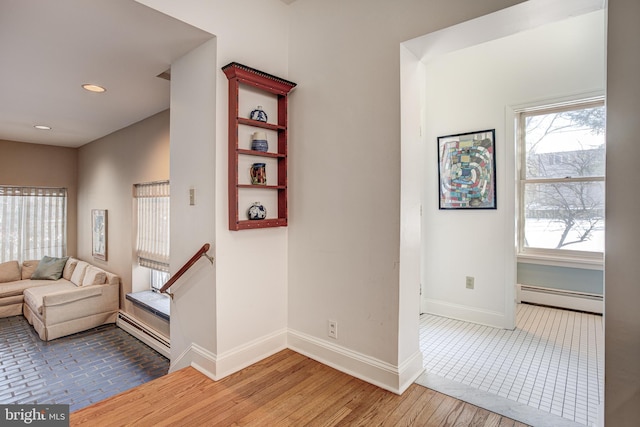 stairway with hardwood / wood-style floors and a baseboard radiator