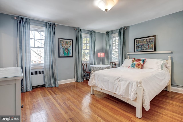 bedroom featuring radiator heating unit and light wood-type flooring