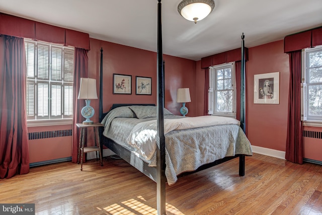 bedroom featuring radiator heating unit and light hardwood / wood-style floors