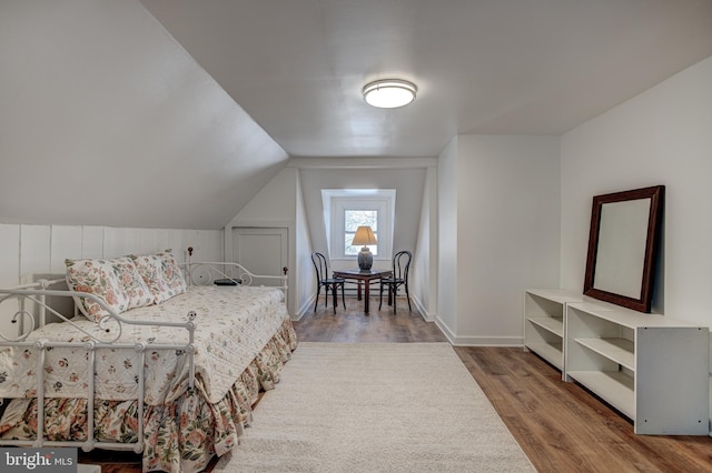 bedroom featuring hardwood / wood-style flooring and lofted ceiling