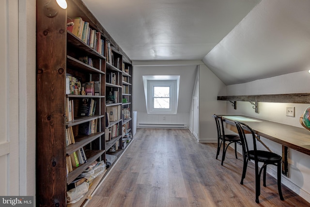 home office with hardwood / wood-style flooring, baseboard heating, and vaulted ceiling