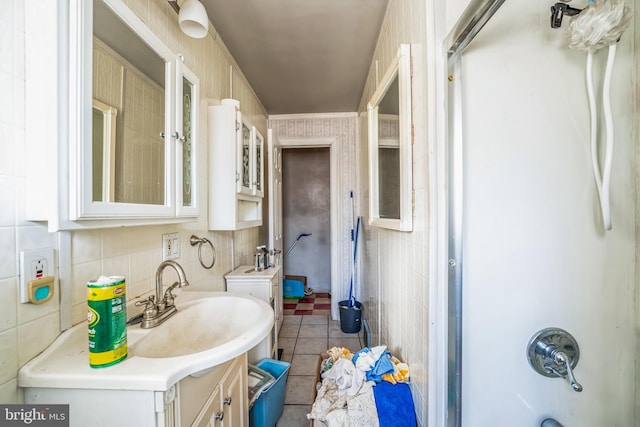 bathroom featuring tile patterned flooring, vanity, washtub / shower combination, and tile walls