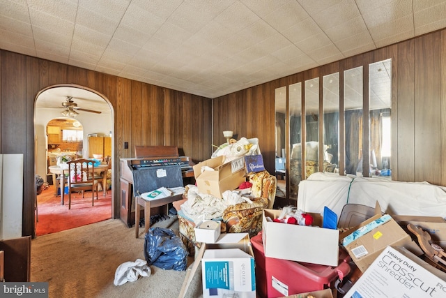 miscellaneous room featuring ceiling fan, carpet floors, and wooden walls