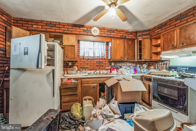 kitchen featuring sink, white appliances, ceiling fan, and brick wall