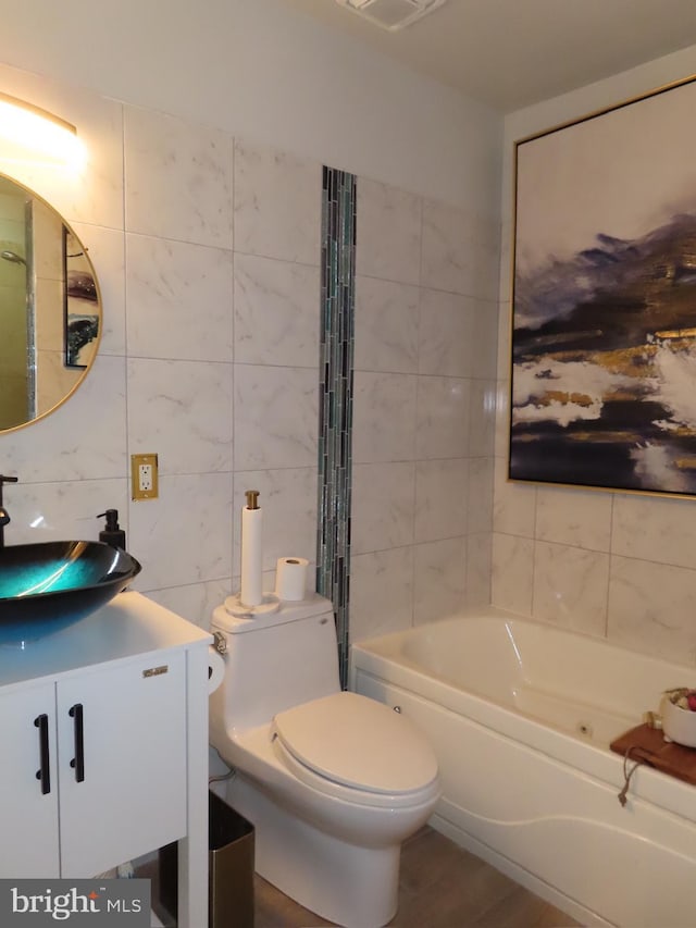 bathroom with wood-type flooring, vanity, toilet, and tile walls