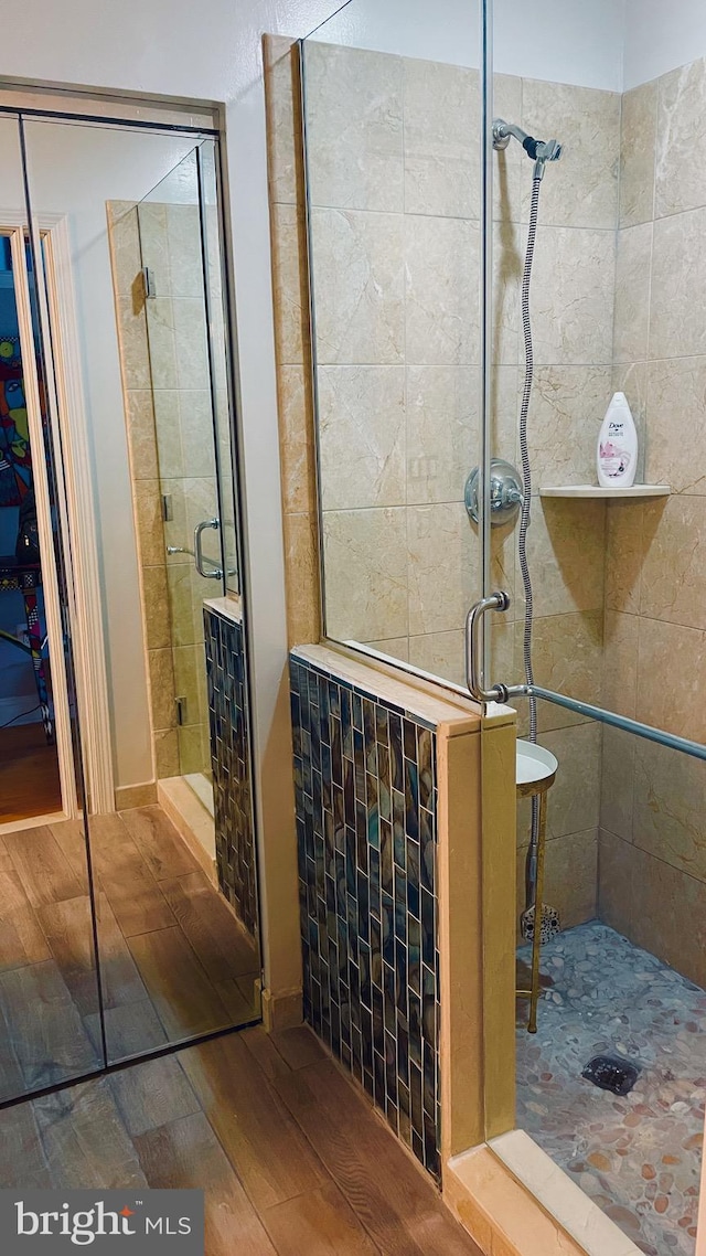 bathroom featuring hardwood / wood-style flooring and walk in shower