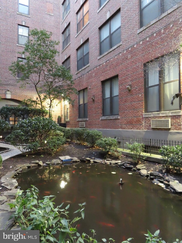 view of building exterior featuring a small pond