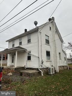 back of house with a yard and central AC