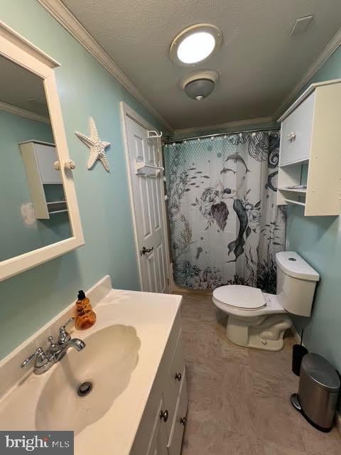 bathroom featuring a shower with curtain, crown molding, vanity, and toilet