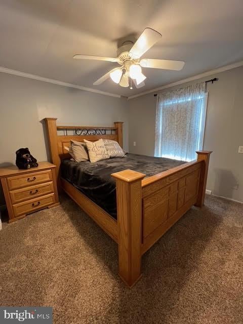 carpeted bedroom with ceiling fan and crown molding