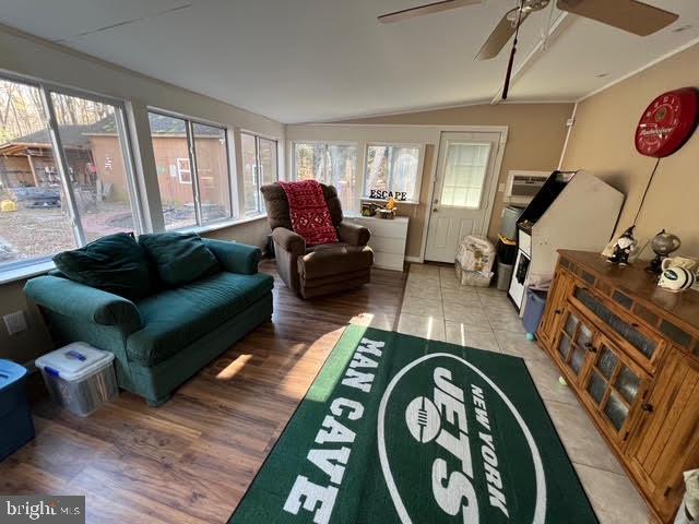 sunroom featuring vaulted ceiling and ceiling fan